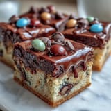 Chewy graduation cookie bars topped with colorful candy-coated chocolates and a white chocolate drizzle, perfect for celebrating academic success.