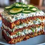 Savory pickle cake with tangy dill frosting, a unique layered appetizer for guests.
