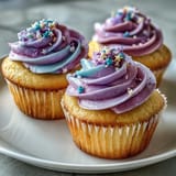 Bright vanilla Gemini Birthday Cupcakes showcase a vibrant, dual-tone frosting swirl.