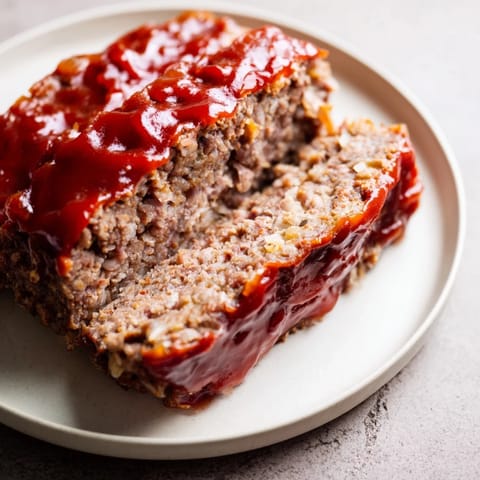 Savory meatloaf, topped with a glistening glaze, perfect for a classic American family dinner.
