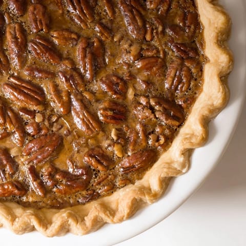 Warm, freshly baked Pecan Pie with a rich, caramel-like filling and crunchy nuts.