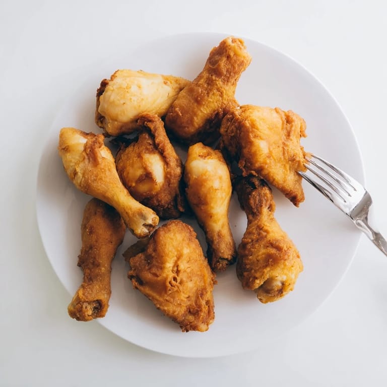A close-up of delicious, juicy fried chicken, showing the seasoned, crunchy exterior and tender meat.