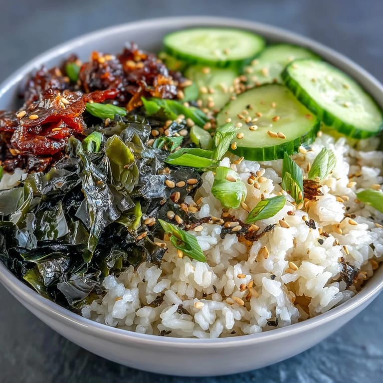 Colorful nori and wakame rice bowl garnished with scallions and cucumber, perfect for a light vegan meal.