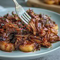 1. Juicy pulled pork simmered with sweet peaches and honey in a tangy BBQ sauce, perfect for summer gatherings.  