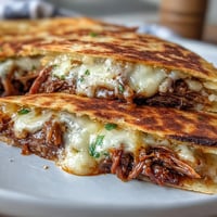 Golden-brown Cinco de Mayo Birria Quesadillas with savory consommé for dunking.